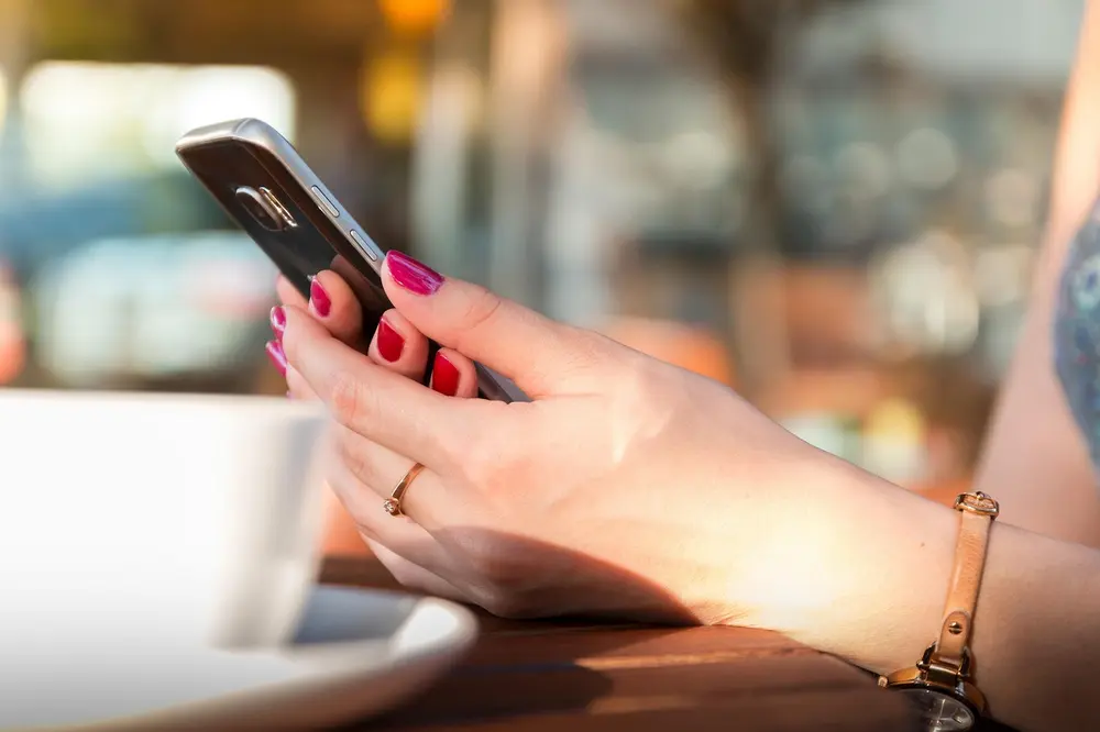 Cliente usando smartphone para ler QR Code de cardápio digital em embalagem de delivery