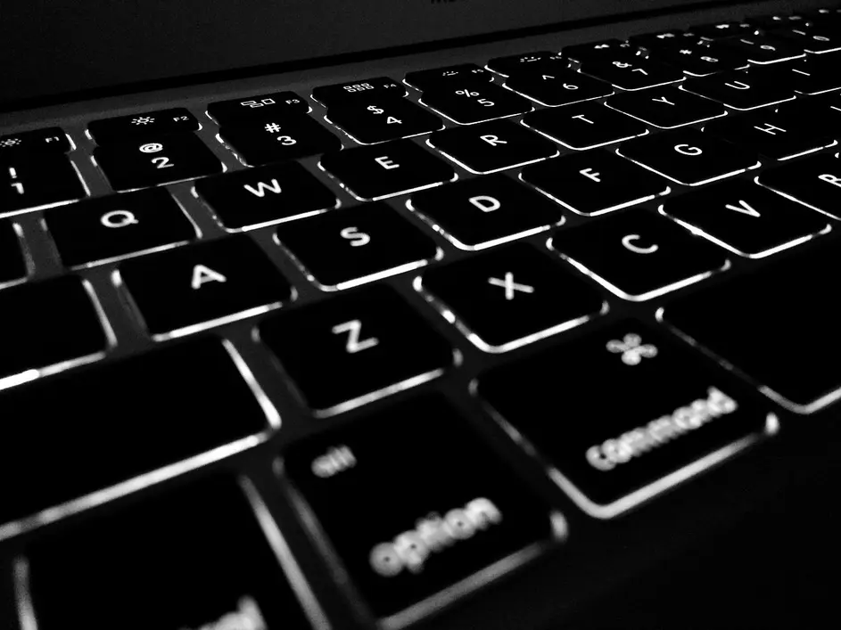 mulher utilizando laptop com visualização de dados criptografados e IA segura em ambiente corporativo